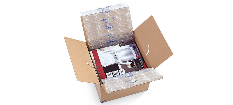 A cardboard box containing a coffee maker and air cushions