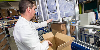 Man inspecting an air cushion packaging system in a warehouse.