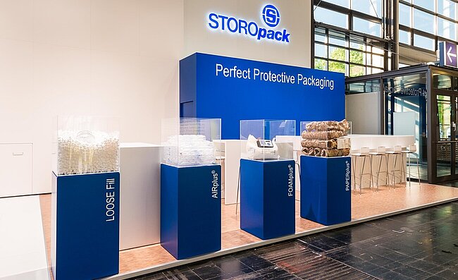 A Storopack trade fair stand with four blue display cases