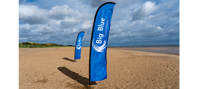 A Big Blue Ocean Cleanup flag on the beach