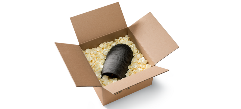 A cardboard box containing a vase and saddle-shaped yellow packaging chips