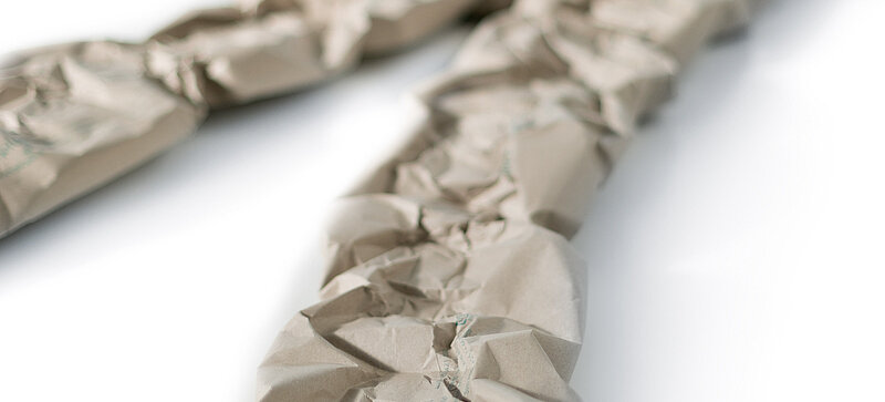 Two paper cushioning strips made from grass paper