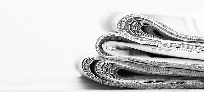 A stack of three newspapers