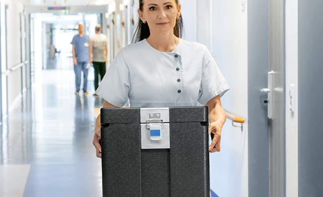 A nurse carrying an insulated box